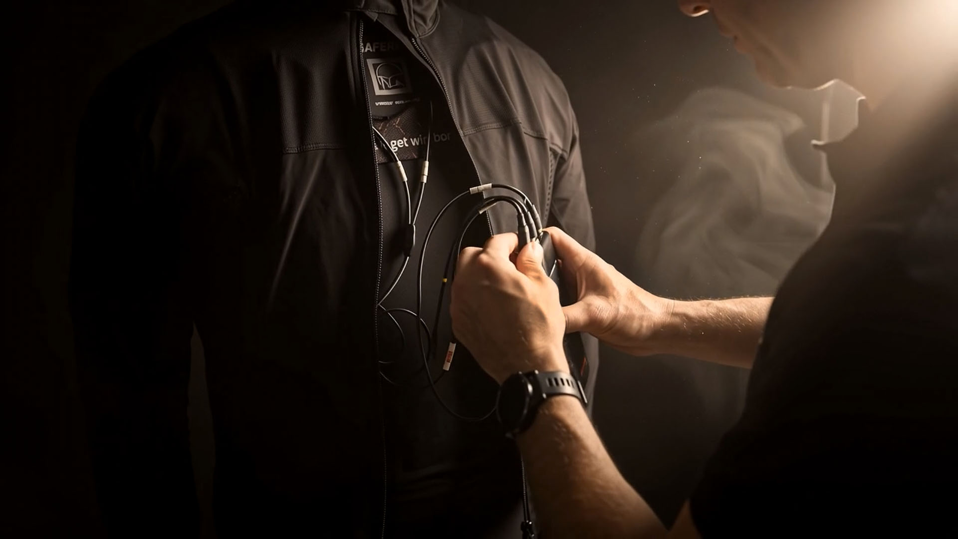 Technician connecting Xsens sensors to the wireless transmitter for a real-time MOCAP session.